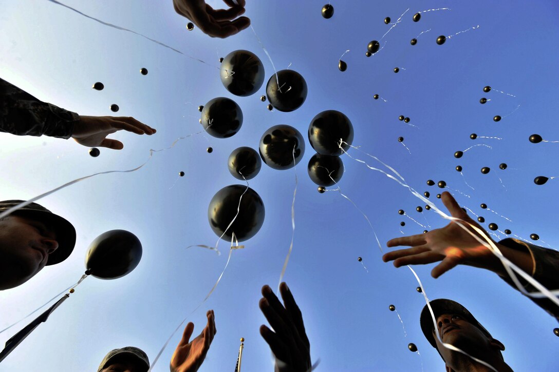 Balloons float upward from outstretched hands.
