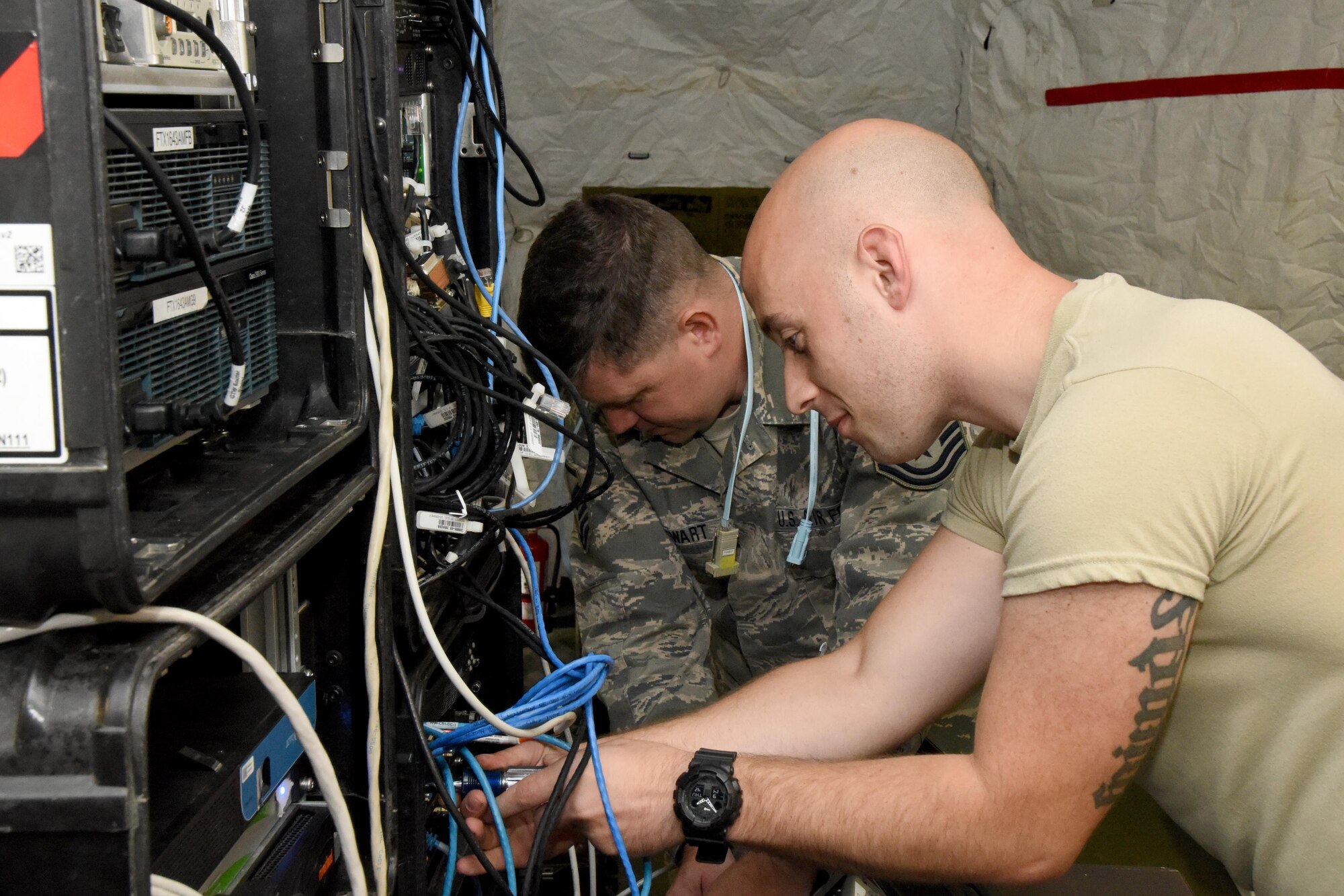 Master Sgt. Edward Stewart and Tech. Sgt. Justin Deal, 269th Combat Communications Squadron connect cables as they set up a wireless internet system at Wright-Patterson Air Force Base, Fairborn, Ohio for the United States Air Force Marathon Sept. 14, 2017.