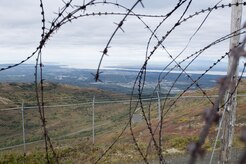 Joint Base Elmendorf-Richardson and downtown anchorage are seen through barbed wire at Nike Site Summit, Sept. 9, 2017. Nike Site Summit was constructed in 1959 as a response to the advanced Soviet bombers of the 1950s. The site was then decommissioned in 1979.