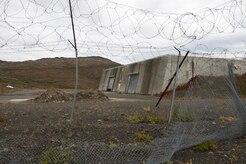 A dilapidated fence hangs in front of the missile launch and storage area at Nike Site Summit, at Joint Base Elmendorf-Richardson, Alaska, Sept. 9, 2017. Nike Site Summit was constructed in 1959 as a response to the advanced Soviet bombers of the 1950s. The site was then decommissioned in 1979.