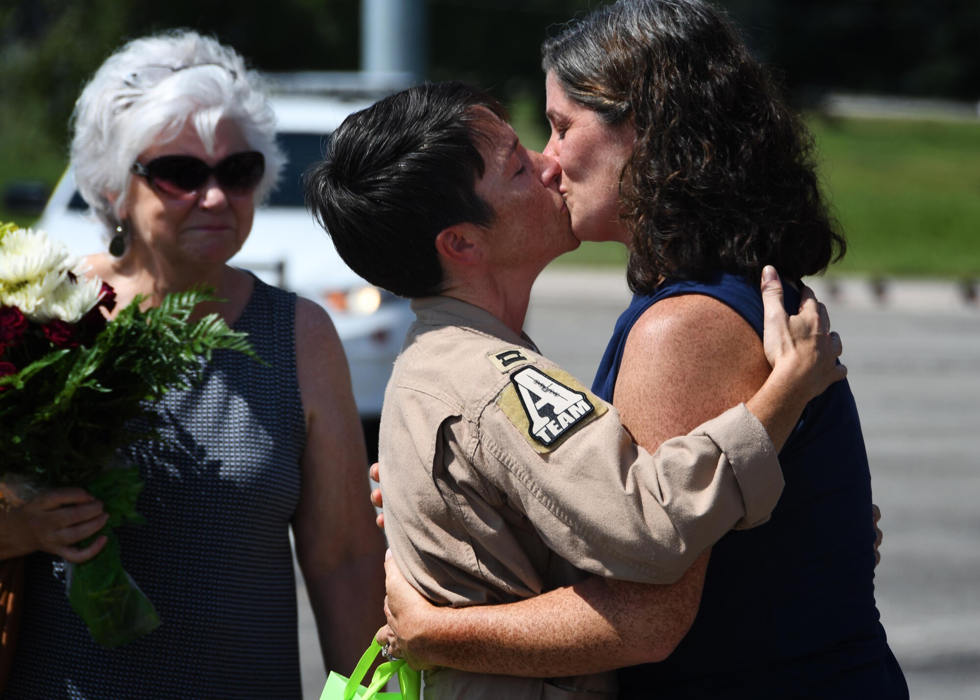 Capt. Rendi Clegg, 700th Airlift Squadron navigator, kisses her wife at Dobbins Air Reserve Base, September 18, 2017. Glegg returned to Dobbins after a four month deployment to Al Udeid Air Base, and found wife waiting for her, along with the friends and family of the other Deployers who arrived with Clegg. (U.S. Air Force Photo by Staff Sergeant Miles Wilson)