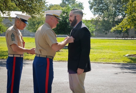 SAN ANTONIO (Sept. 8, 2017)  Lt. Col. William O'Brien, commanding officer, 3D Assault Amphibian Battalion in Camp Pendleton, California, pins the Navy and Marine Corps Medal on Marine Corps veteran Corporal Randy D. Mann during a ceremony in the historical quadrangle at Joint Base San Antonio - Fort Sam Houston, Texas. Mann was awarded the medal during the ceremony in his hometown of San Antonio for his heroic actions while on active duty with the 3D Assault Amphibian Battalion in July 2013. (U.S. Navy photo by Mass Communication Specialist 1st Class Jacquelyn D. Childs/Released)