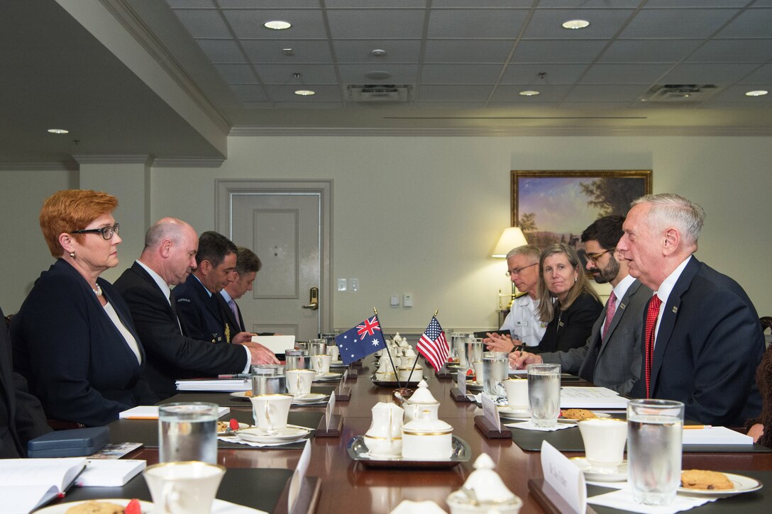 Defense Secretary Jim Mattis sits at a table with several other people.