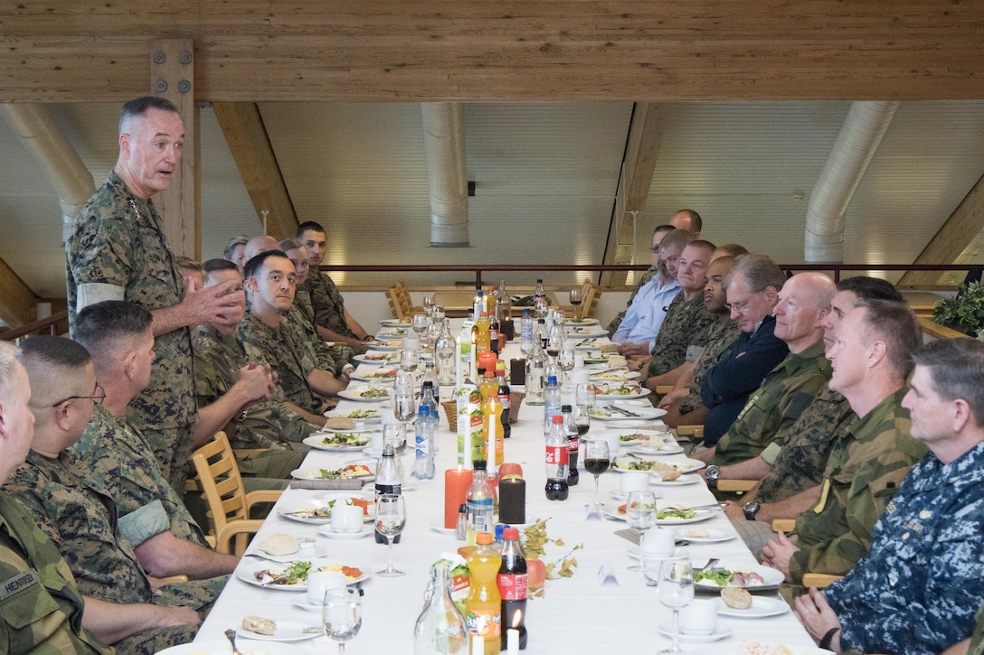 Marine Corps Gen. Joe Dunford speaks to Marines sitting at a table during a meal.