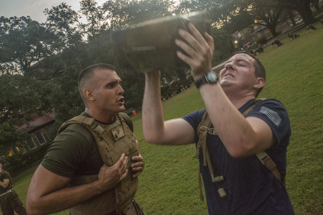 Marine Corps Sgt. Ian Ferro (left), a combat correspondent with Headquarters Battalion, Marine Forces Reserve, motivates a Naval Reserve Officers Training Corps midshipman during ammo can lifts at Tulane University in New Orleans, Sept. 20, 2017.