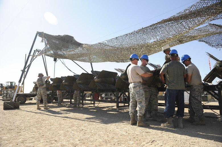 Senior officers (blue helmets) work in conjunction with munitions Airmen during an officer orientation course geared toward giving them a hands on experience on the tactical demands of bomb building at Beale Air Force Base, California, August 30, 2017. The munitions were assembled on a mobile Munitions Assembly Conveyor. (U.S. Air Force photo/Senior Airman Justin Parsons)