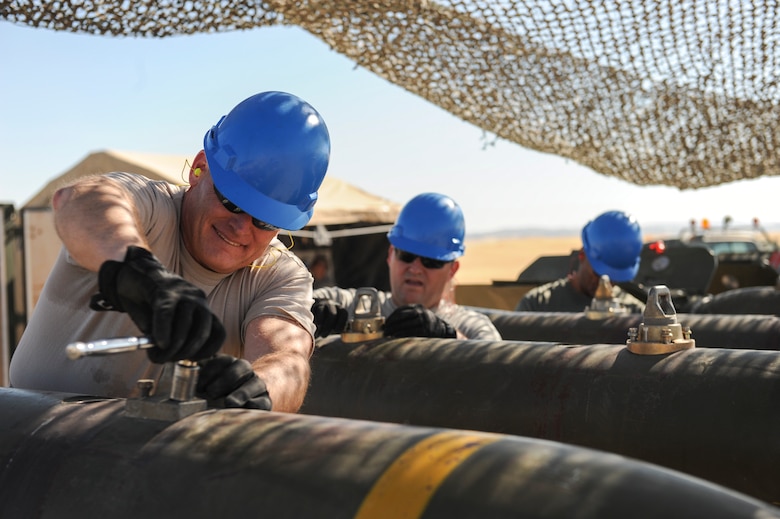 Senior officers and contractors make a final inspection of all fasteners on the bodies of a MK-84 bomb to ensure it meets set standards at Beale Air Force Base, California, Aug. 30, 2017. The weapon system is required to meet all assembly standards to ensure the munitions functions correctly when deployed. (U.S. Air Force photo/Senior Airman Justin Parsons)