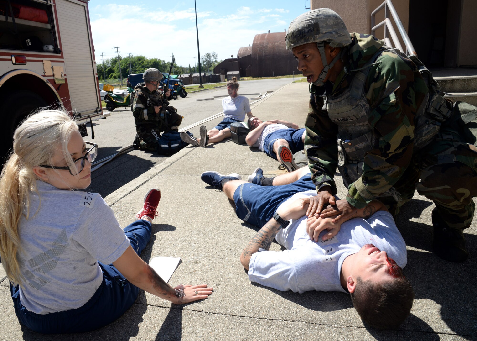Tech Sgt. Michael Randall, far right, 51st Security Forces Squadron defender, attends to the wounds of multiple victims during a simulated building fire portion of exercise Beverly Herd 17-3 at Osan Air Base, Republic of Korea September 20, 2017. The exercise was held to evaluate the readiness and initial actions of the base First Response Team under realistic scenario simulations. (U.S. Air Force photo by Tech Sgt. Ashley Tyler)