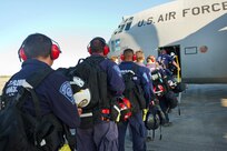 A line of people wait to board an aircraft.