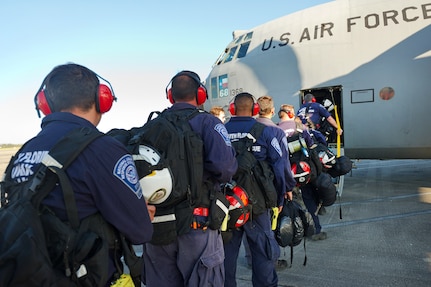 A line of people wait to board an aircraft.