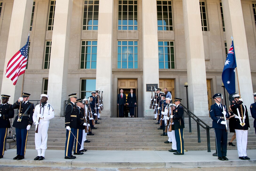 Defense Secretary Jim Mattis stands with Australian defense minister on steps with service members.