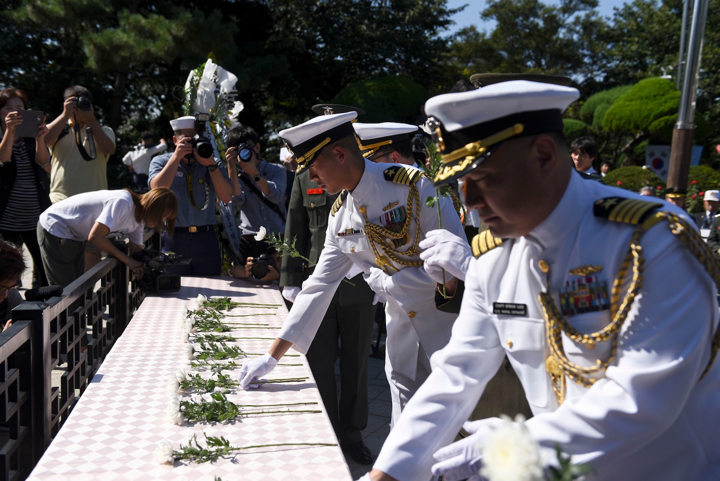 Capt. Hank Kim, chief of staff of Commander, U.S. Naval Forces Korea, and Capt. Kwang Lee, U.S. Navy Attache', lay flowers at the Gen. Douglas MacArthur statue during the 67th Incheon Landing Operations Commemoration Ceremony. Incheon landing was a combined U.S. and ROK military assault during the Korean War is considered one of the most significant and successful operations in the history of amphibious warfare.
