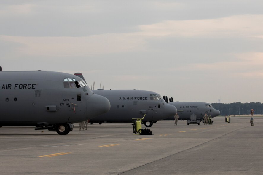 A crew chief from the 374th Aircraft Maintenance Squadron marshals a C-130J Super Hercules at Yokota