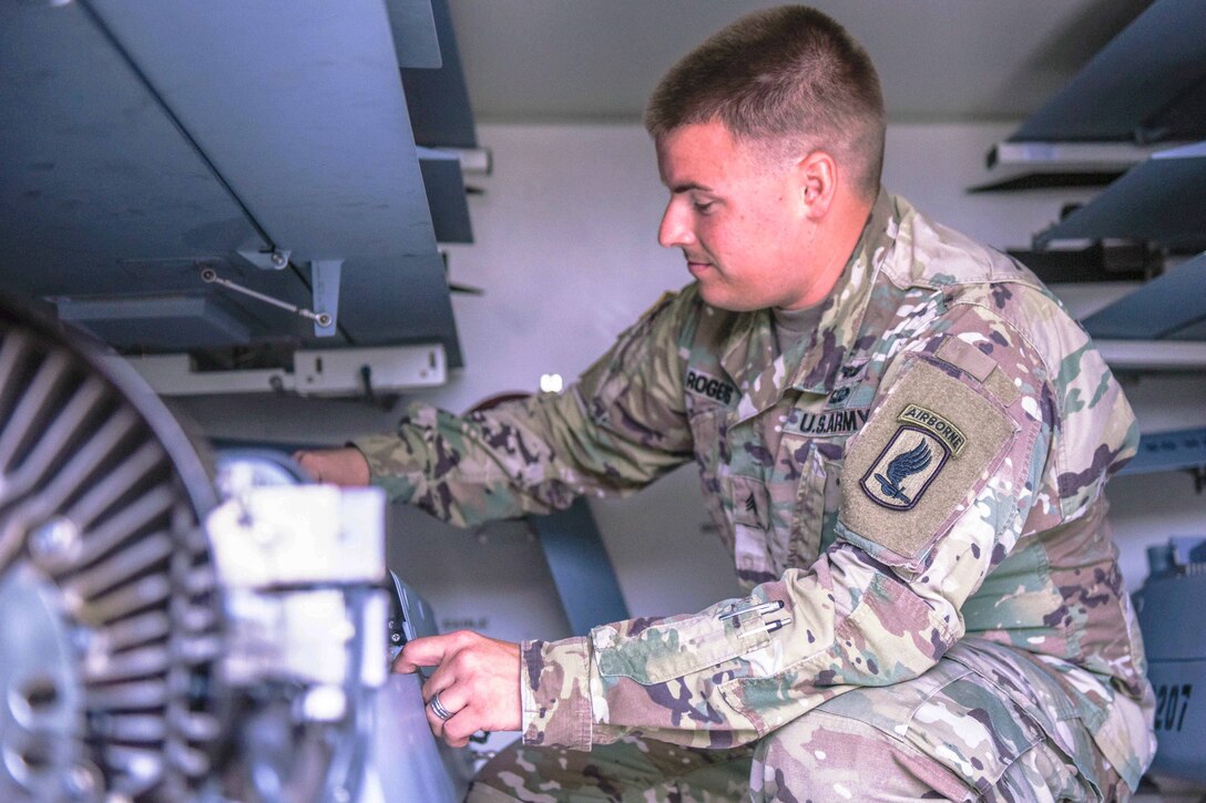 A soldier inspects some equipment.
