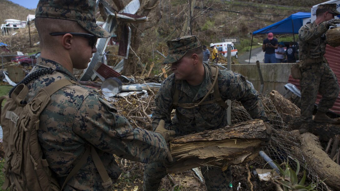 U.S. Marine Corps Lance Cpl. Brandon L. Mills, center, a mortarman with Battalion Landing Team 2nd Battalion, 6th Marine Regiment, 26th Marine Expeditionary Unit (MEU), moves debris that is blocking a drainage site at a local fire station that was affected by Hurricane Irma in St. John, U.S. Virgin Islands, Sept. 17, 2017. The 26th MEU is supporting authorities in the U.S. Virgin Islands with the combined goal of protecting the lives and safety of those in affected areas.