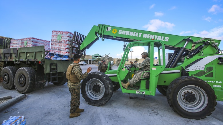 Marines and Soldiers work together to unload cases of water to a distribution point in Key West, Fl., Sept. 14, 2017. Marines and Sailors with the 26th Marine Expeditionary Unit helped distribute food, water, and supplies in support of the Federal Emergency Management Agency in the aftermath of Hurricane Irma.