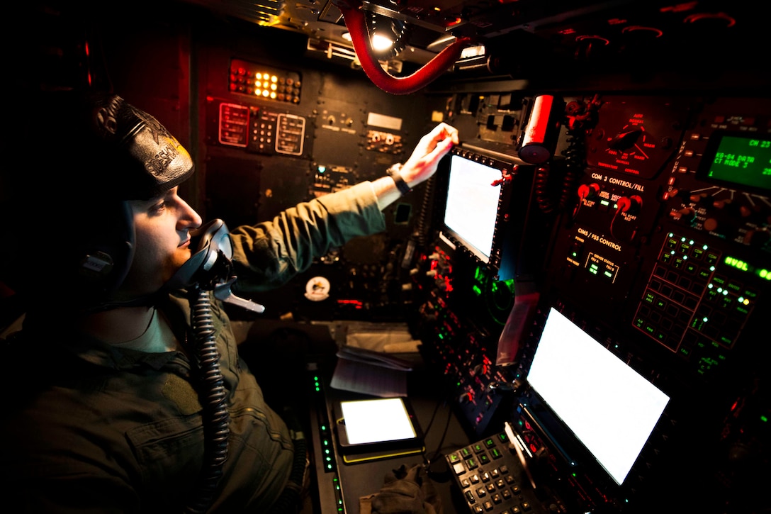 An airman watches monitors on an aircraft.