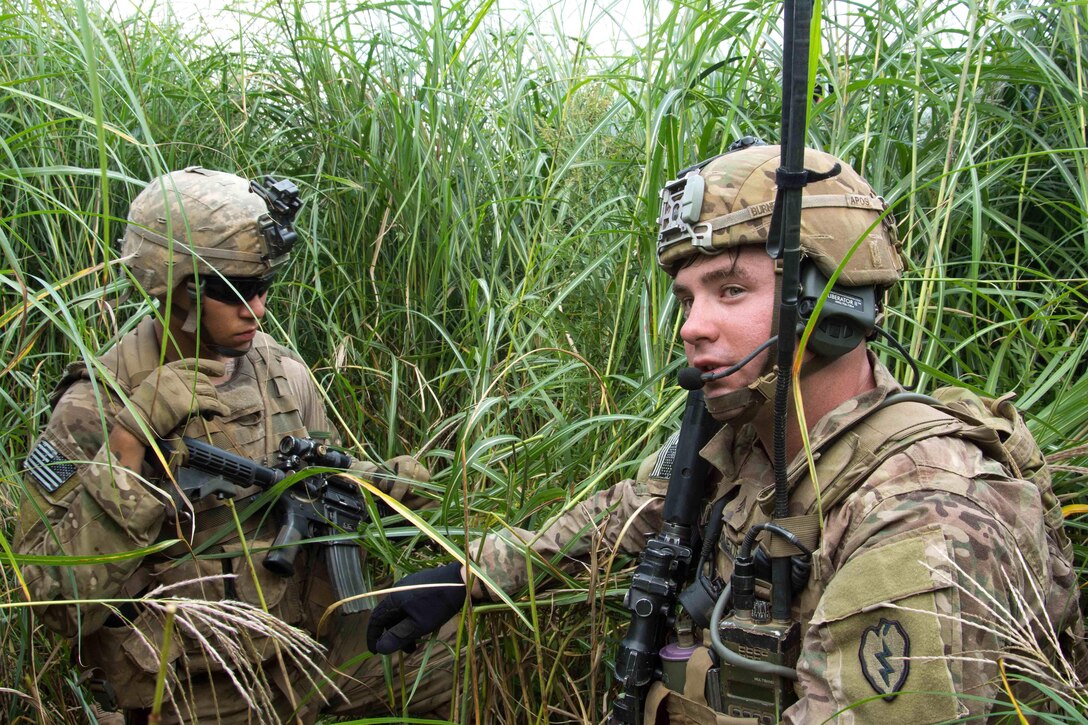 A soldier provides instructions to a squad member during a live-fire training.