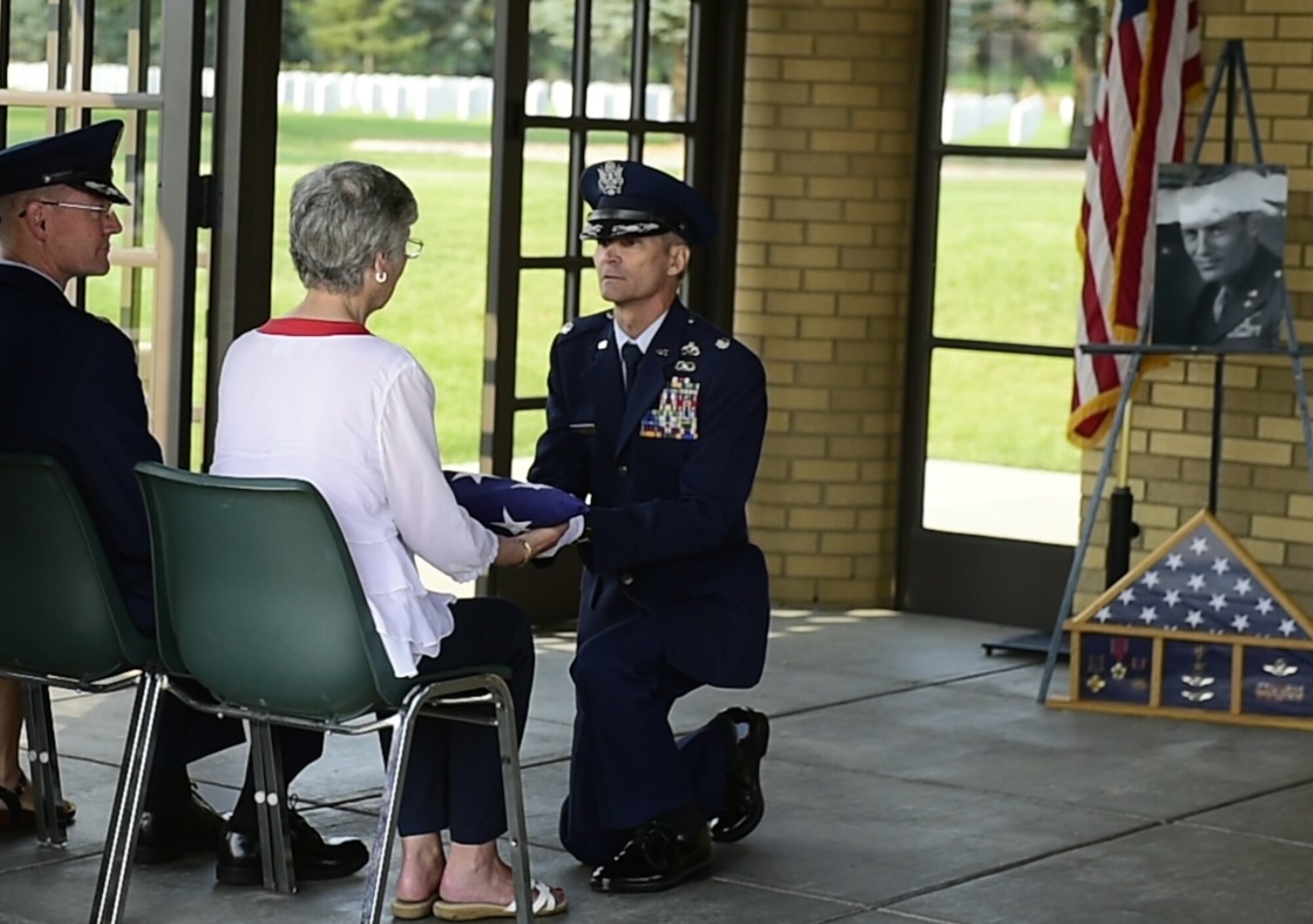 Lt. Col. Thomas J. Nefe, Director of Resources and Readiness, 240th Civil Engineer Flight, Colorado Air National Guard, Buckley AFB, presents the American flag to Linne (Royal) Haddock during the memorial service at Logan National Cemetery in Denver for Haddock’s father, Col. Frank Royal, who passed away in November. Royal commanded the 39th Fighter Squadron during World War II in New Guinea, making one air-to-air kill July 4, 1942. (Photo by Senior Airman Alyssa Duprey, 460th Space Wing Public Affairs).