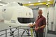 Robert Brown, a C-17 flight simulator project officer with the 445th Airlift Wing discusses the C-17 simulator in the background. (U.S. Air Force photo / Brian Brackens)