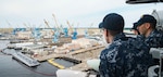 A sailor assigned to the aircraft carrier USS Dwight D. Eisenhower (CVN 69) observe as the ship pulls into Norfolk Naval Shipyard in Portsmouth, Va.