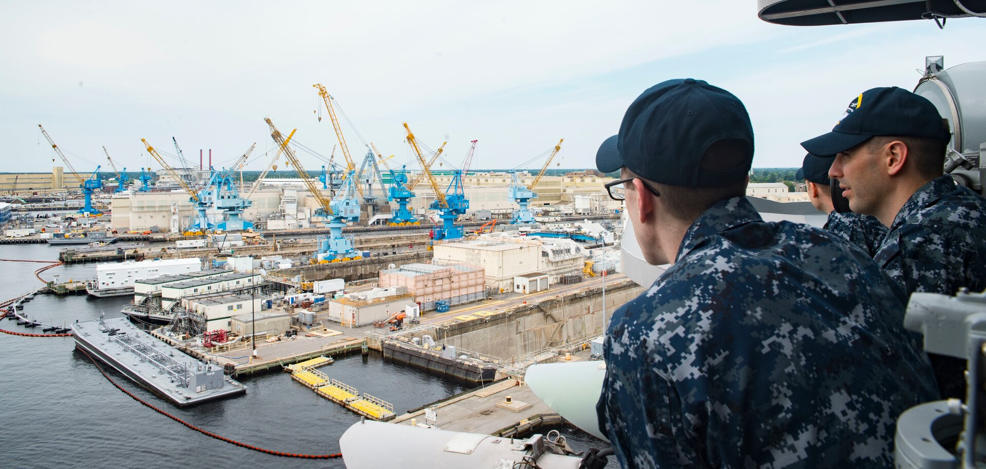 A sailor assigned to the aircraft carrier USS Dwight D. Eisenhower (CVN 69) observe as the ship pulls into Norfolk Naval Shipyard in Portsmouth, Va.