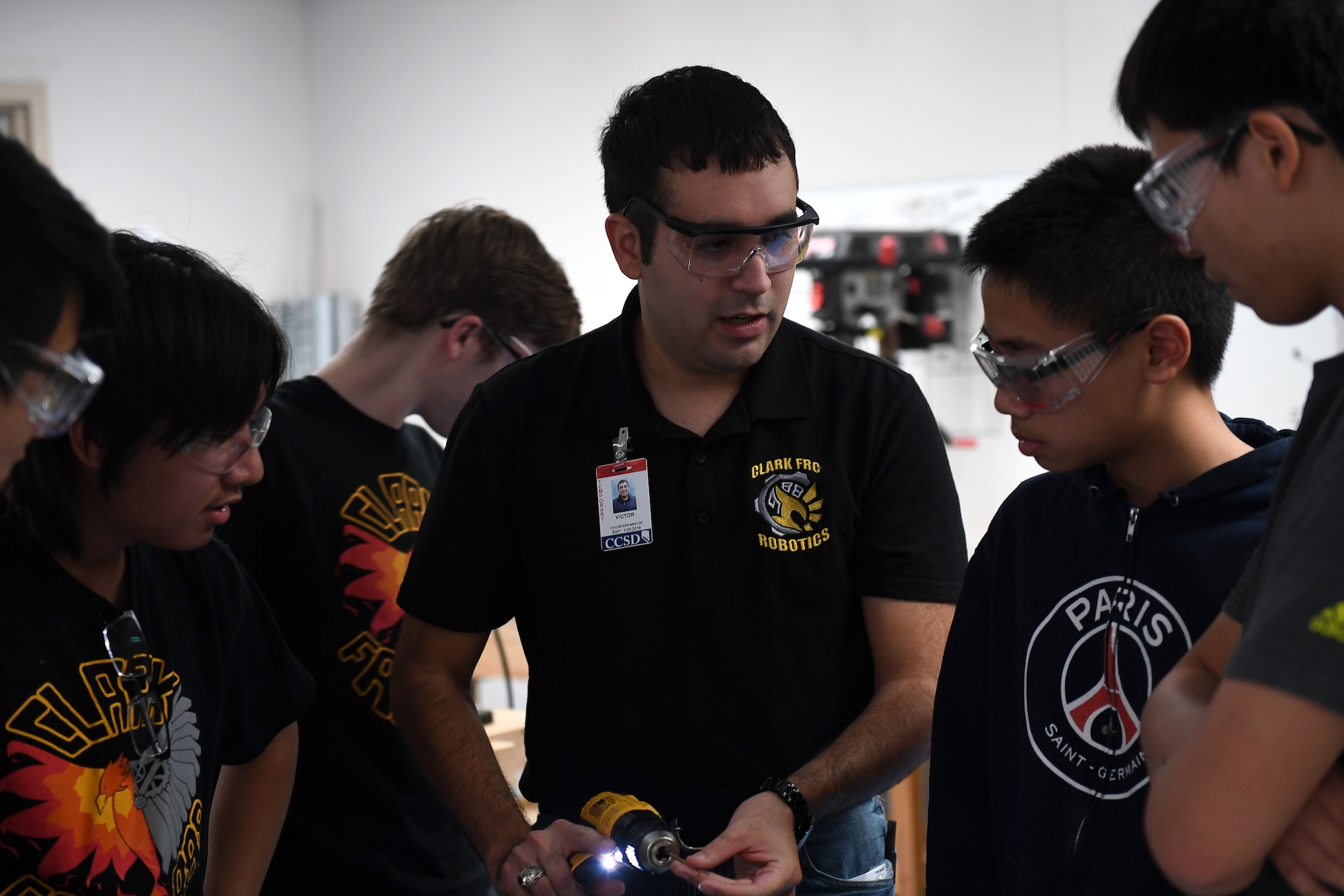 Capt. Victor, 17th Attack Squadron MQ-9 Reaper pilot, shows a high school robotics team how to work with an electric drill, in Las Vegas, Sept. 7, 2017.