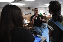 Capt. Victor, 17th Attack Squadron MQ-9 Reaper pilot, instructs a couple of robotics students, in Las Vegas, Sept. 7, 2017.