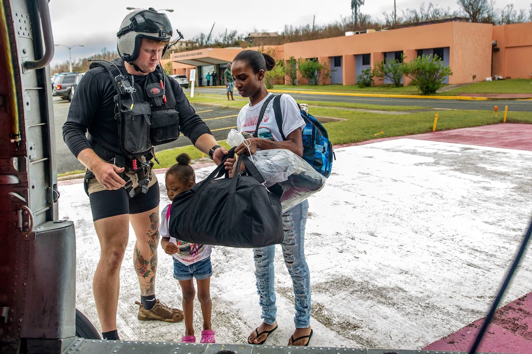 A sailor prepares family members for evacuation.