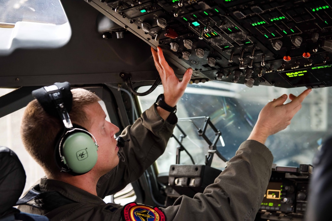 A pilot performs preflight checks inside the cockpit of a C-17 C-17 Globemaster III
