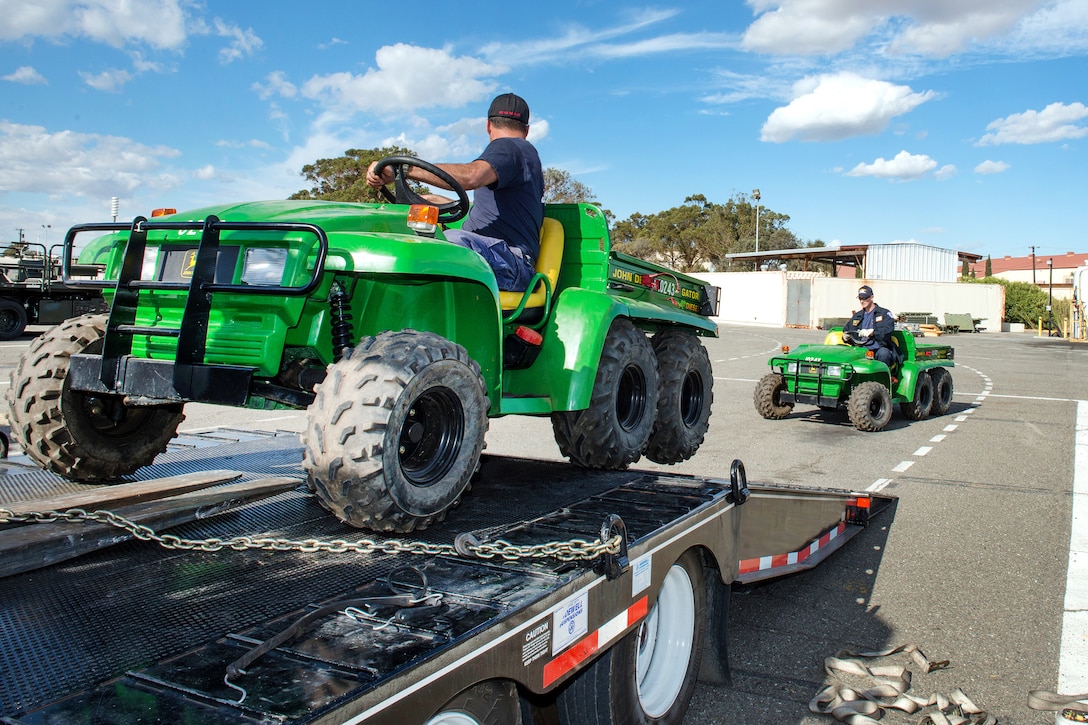All-terrain vehicles are offloaded from a truck.
