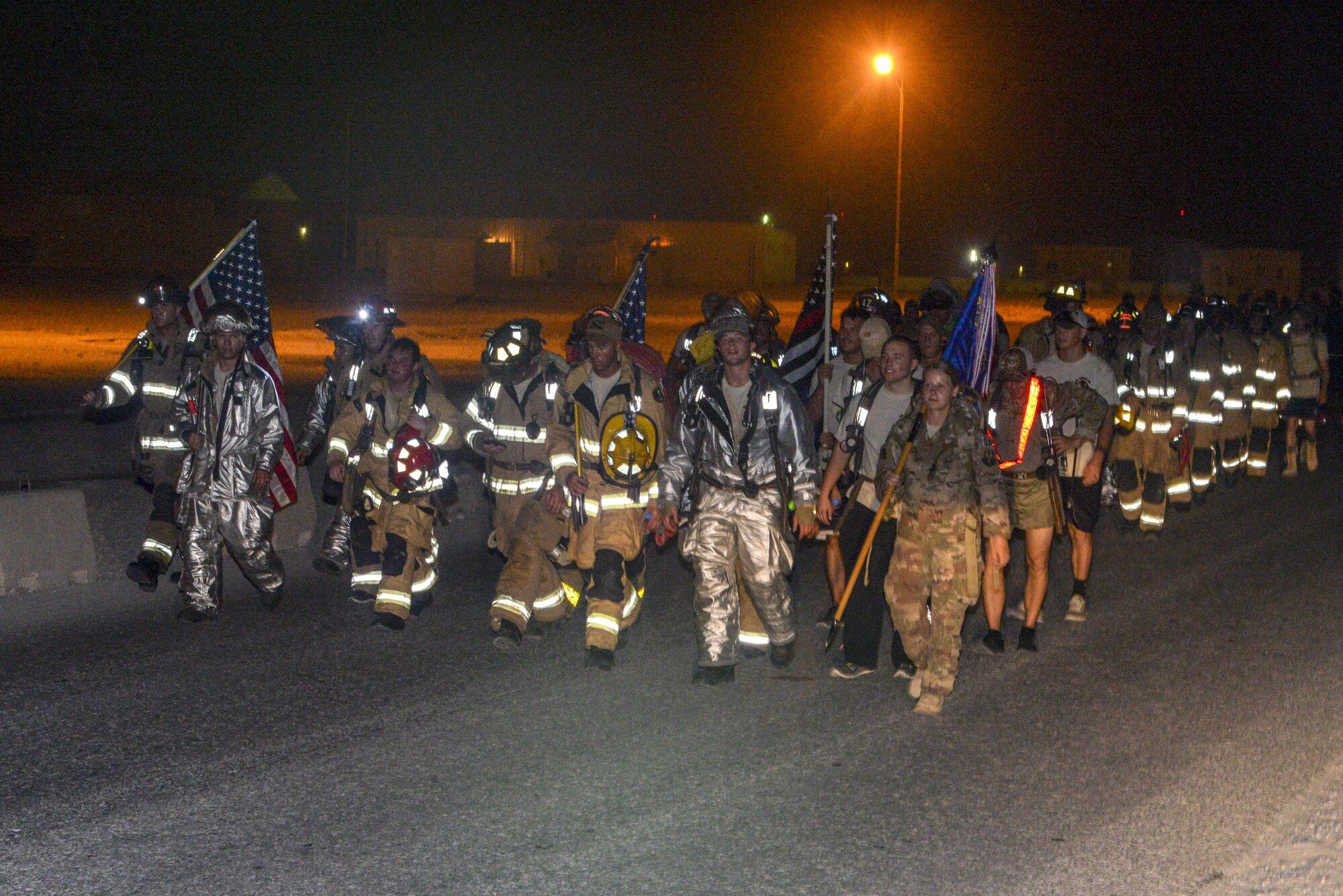 U.S. Air Force fire department and security forces members participate in an evening memorial walk at Al Udeid Air Base, Qatar, Sept. 11, 2017.