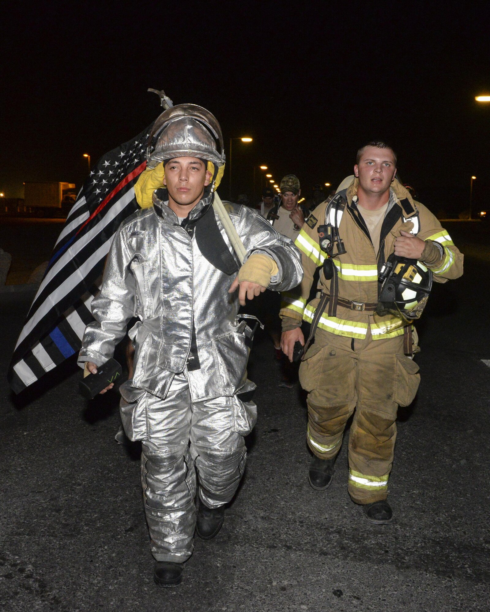 U.S. Air Force Senior Airmen Mario Jaquez, left, and Matthew Brooks, firefighters assigned to the 379th Expeditionary Civil Engineering Squadron, participate in an evening 9/11 memorial walk at Al Udeid Air Base, Qatar, Sept. 11, 2017.