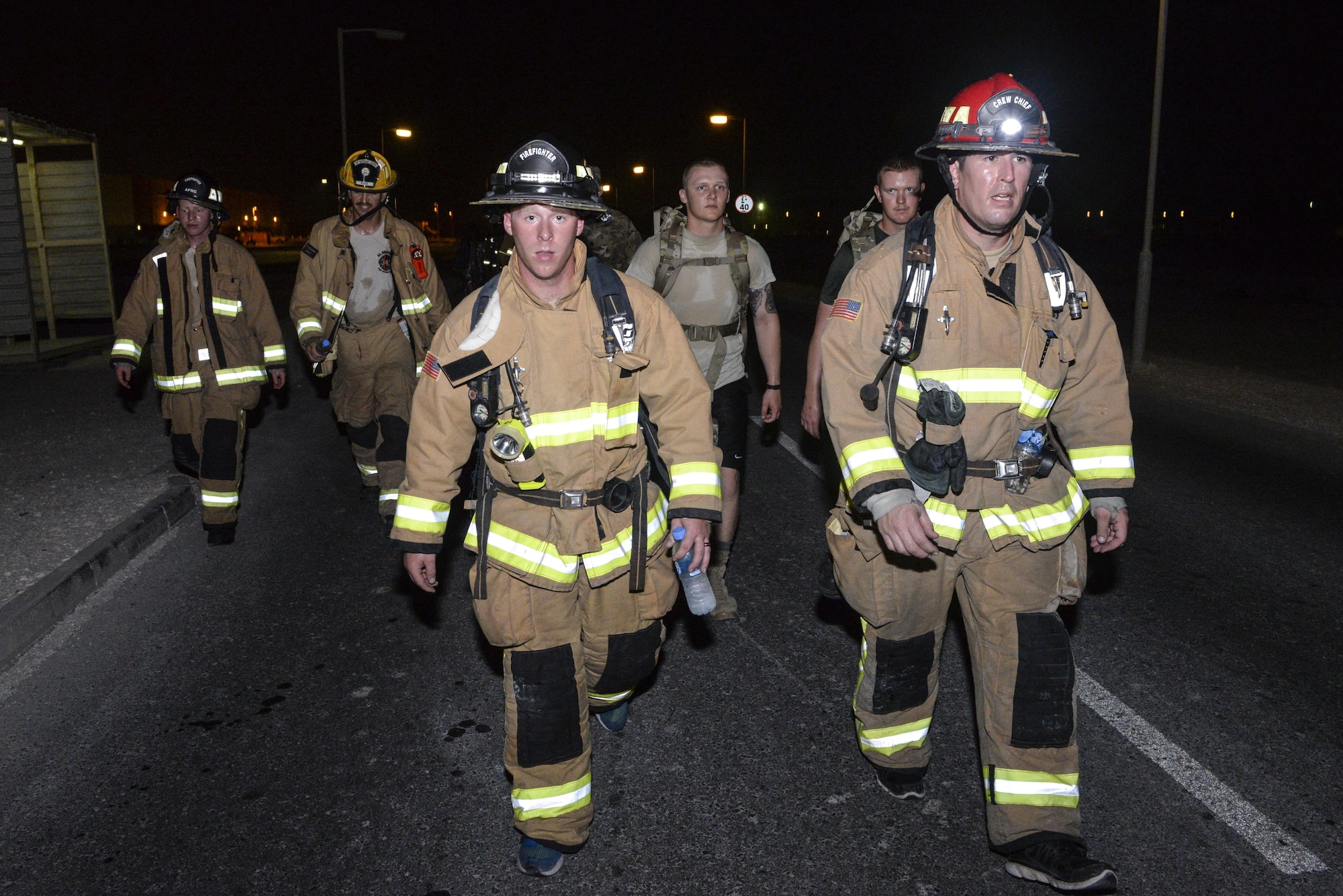 U.S. Air Force Staff Sgt. Allen Patterson, left, and Tech. Sgt. Adam Murray, firefighters assigned to the 379th Expeditionary Civil Engineering Squadron, participate in an evening 9/11 memorial walk at Al Udeid Air Base, Qatar, Sept. 11, 2017.