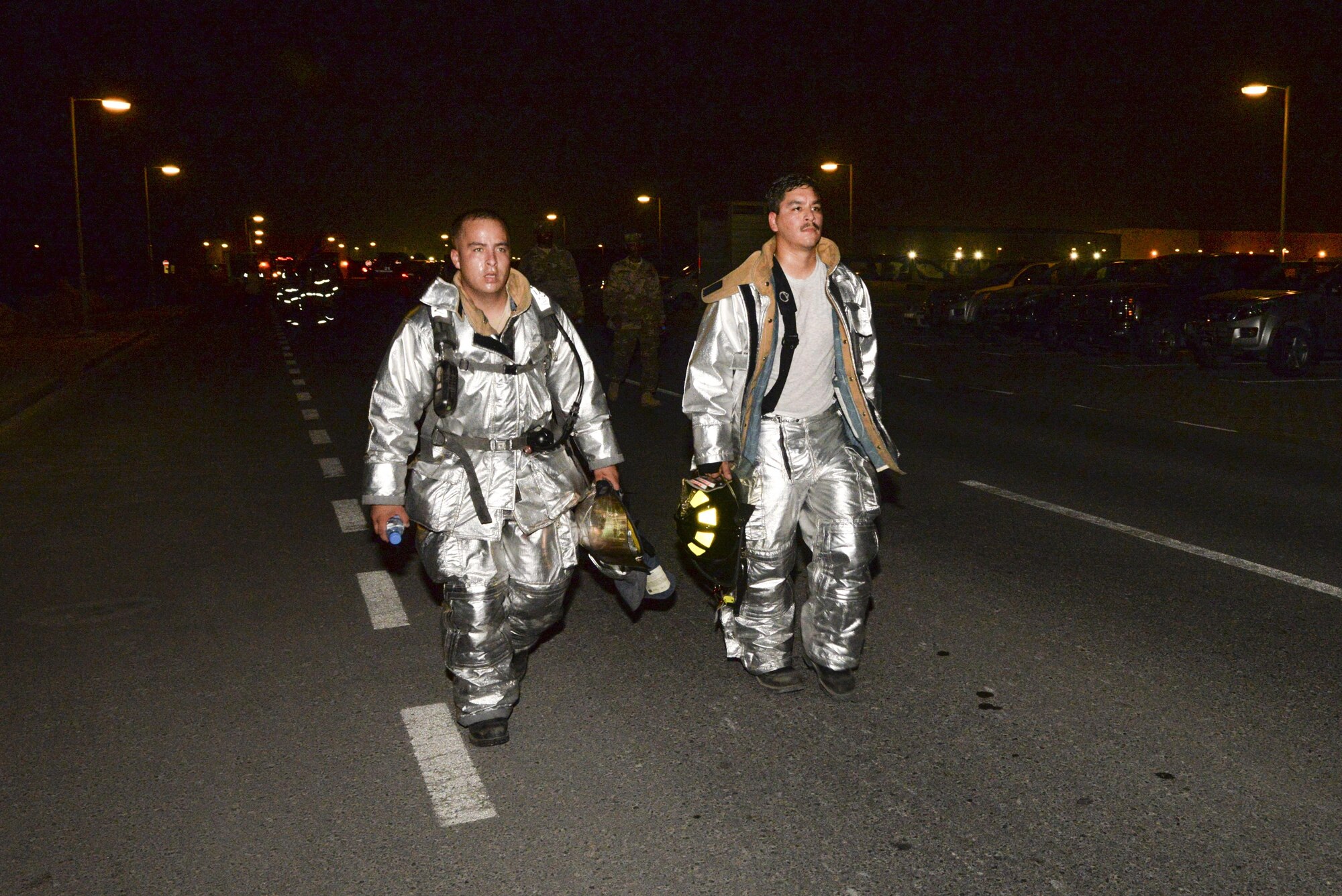 U.S. Air Force Senior Airmen Mario Romero, left, and Daniel Martinez, firefighters assigned to the 379th Expeditionary Civil Engineering Squadron, participate in an evening 9/11 memorial walk at Al Udeid Air Base, Qatar, Sept. 11, 2017.