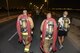 U.S. Air Force firefighters assigned to the 379th Expeditionary Civil Engineering Squadron carry fire hoses and wear self-contained breathing apparatus as they participate in an evening 9/11 memorial walk at Al Udeid Air Base, Qatar, Sept. 11, 2017.