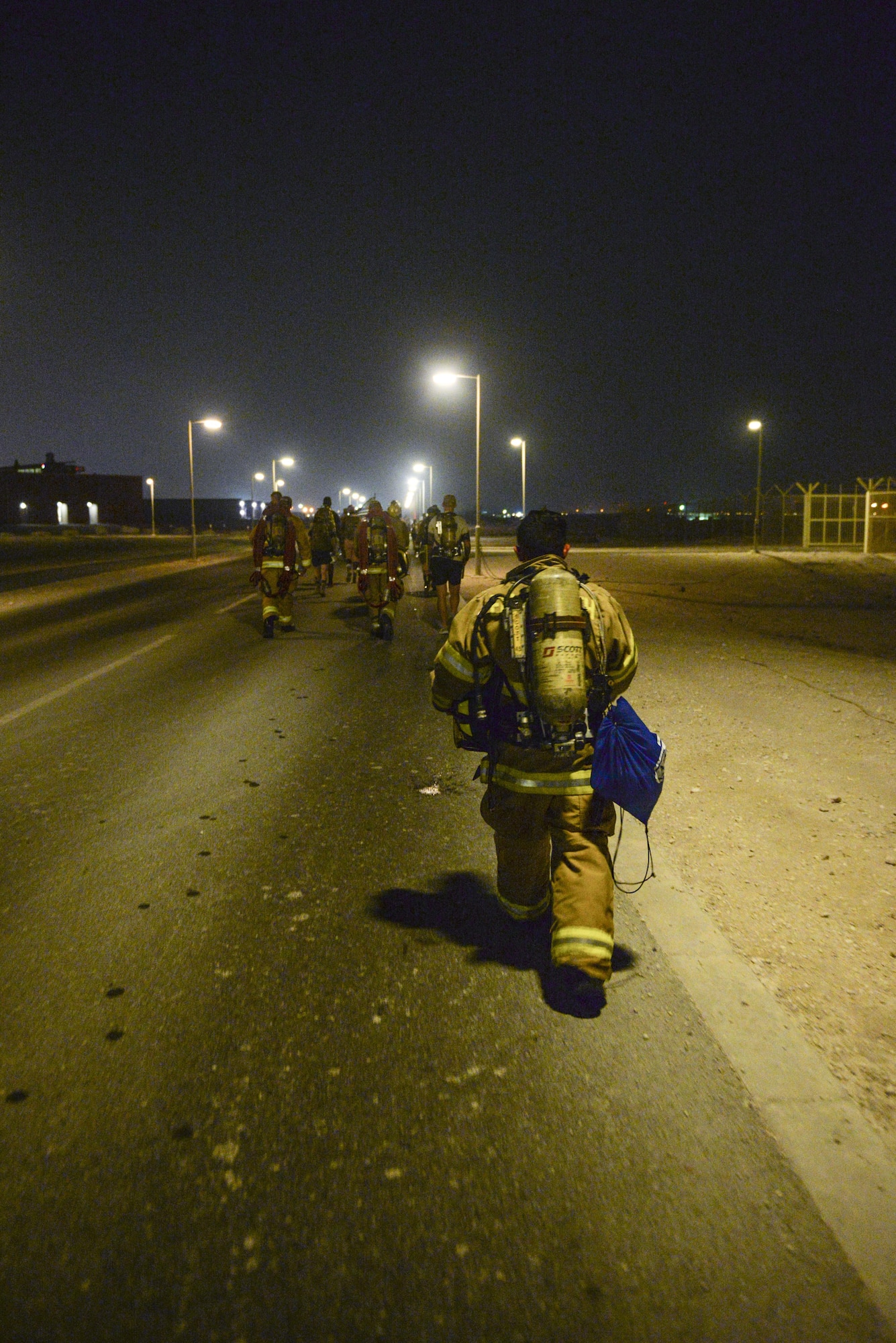 U.S. Air Force firefighters assigned to the 379th Expeditionary Civil Engineering Squadron wear self-contained breathing apparatus as they participate in an evening memorial walk at Al Udeid Air Base, Qatar, Sept. 11, 2017.