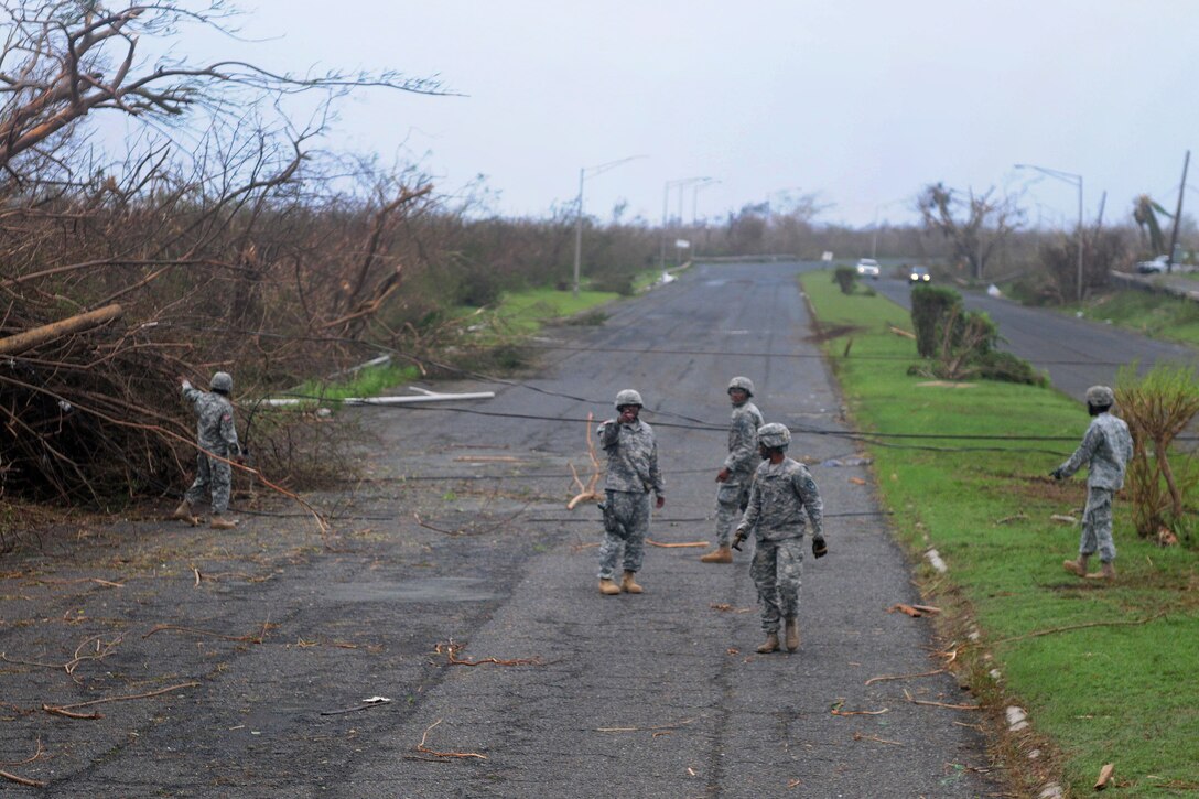 Guardsmen clear debris and downed power lines from the Melvin Evans highway in St. Croix