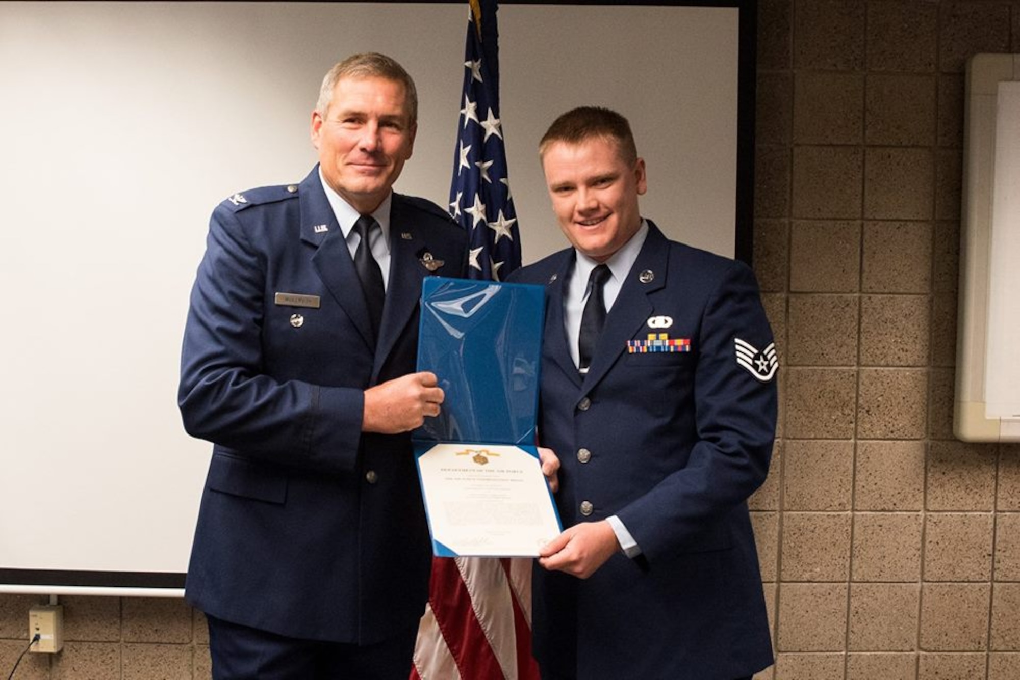 Col. Timothy Wollmuth, 934th Airlift Wing vice wing commander presents Staff Sgt. Steve Johnson, command post controller, with the Air Force Commendation medal Sept. 9, 2017. (Air Force/Master Sgt. Eric Amidon)