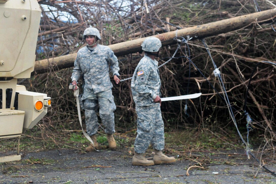 Guardsmen clear debris and downed power lines from the Melvin Evans highway in St. Croix.
