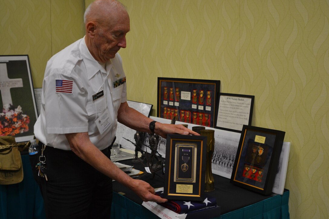 Navy Capt. retired Lee S. Anthony, an 80th Division Veterans Association member and son of Pvt. Lee Hill Anthony, a 80th Training Division World War I veteran, shows the Purple Heart his father earned while serving during WWI. His father was injured April 4, 1918. (U.S. Army photo by Sgt. 1st Class Emily D. Anderson, 80th Training Command)