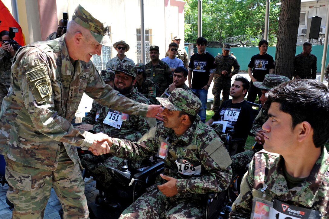 Army Gen. John W. Nicholson shakes the hand of an Afghan wounded warrior in a wheelchair.
