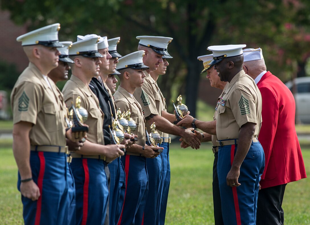The Commandant of the Marine Corps, Gen. Robert B. Neller, the Sergeant Major of the Marine Corps, Sgt. Maj. Ronald L. Green, and a member of the Marine Corps League, deliver awards to enlisted Marines during the Enlisted Awards Parade at the Modern Day Marine Military Exposition (MDMME) at Lejeune Field, Marine Corps Base Quantico, Quantico, Va., Sept. 20, 2017. The MDMME is an annual exposition open to the public to display the progression of equipment and technology that is currently employed and may be utilized with future Marine Corps operating forces. (Official U.S. Marine Corps photo by Cpl. Robert Knapp/Released)