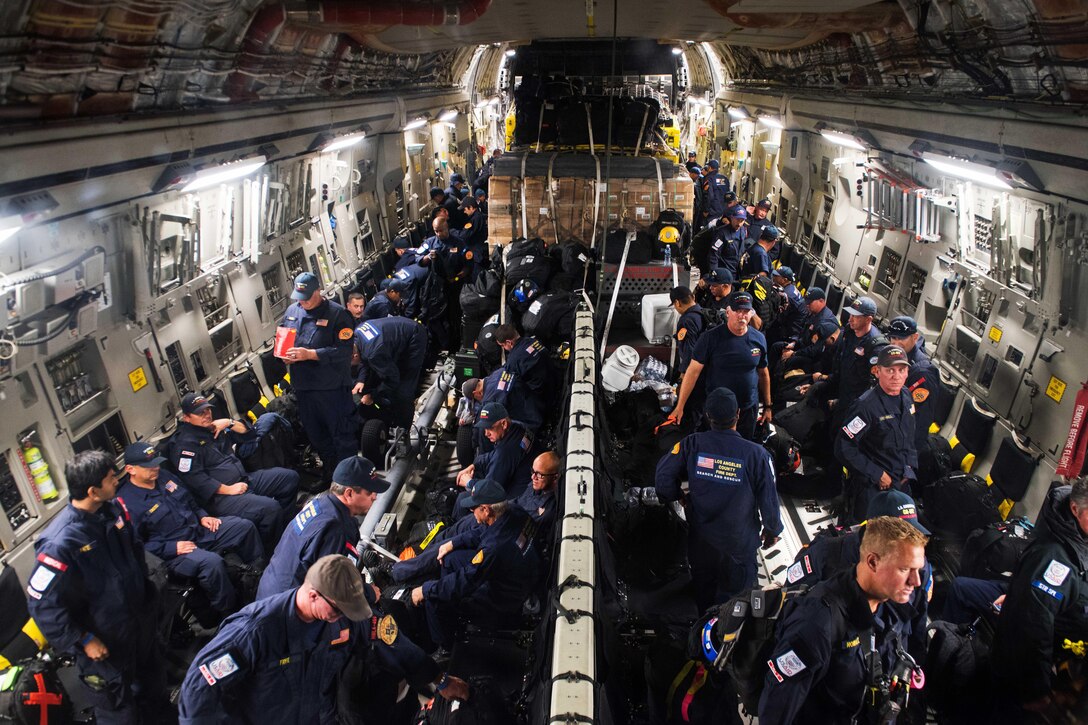 A group of people gather gear inside an aircraft.