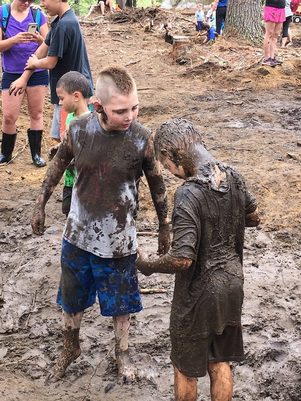 Two boys playing in mud.