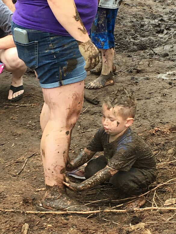 Boy smearing mud on his parent.