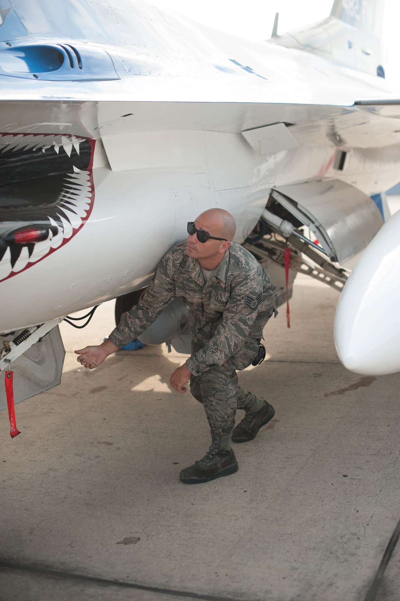 Staff Sgt. Joel Folguiera performs inspections on an F-16 after it relocated to Naval Air Station Fort Worth Joint Reserve Base, Texas, in order to stay out of harm's way during Hurricane Irma.