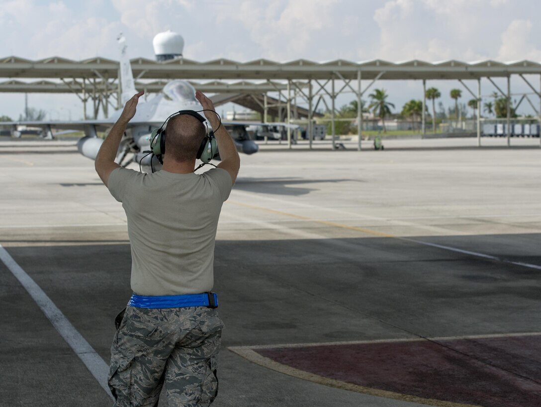A Reserve Citizen Airmen crew chief from the 482 Aircraft Maintenance Squadron, Homestead Air Reserve Base, Florida, marshals an F-16C Viper from the 482nd Fighter Wing into a packing spot as the aircraft returns home after being evacuated September 21, 2017. The aircraft of the fighter wing were evacuated to Texas in advance of Hurricane Irma’s landfall with Florida. (U.S. Air Force Photo by Staff Sgt. Kyle Brasier)