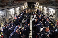A group of people gather gear inside an aircraft.
