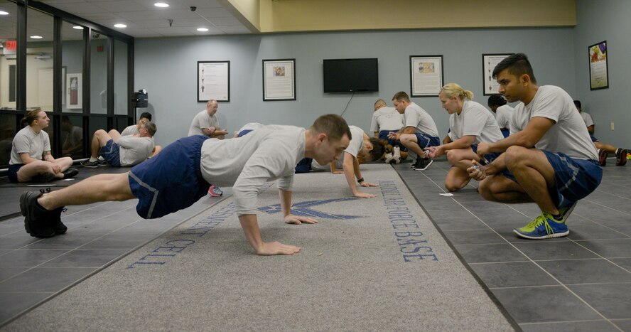 U.S. Air Force Airmen perform the push-up and sit-up portion of their physical fitness test at MacDill Air Force Base, Fla., Sept. 22, 2017. The Air Force physical fitness test consists of push-ups, sit-ups, a waist circumference measurement and a mile and a half run. (U.S. Air Force photo by Senior Airman Mariette Adams)